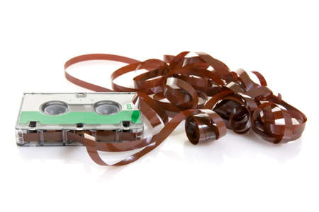 Classic audio cassette with tape coming out on white background 