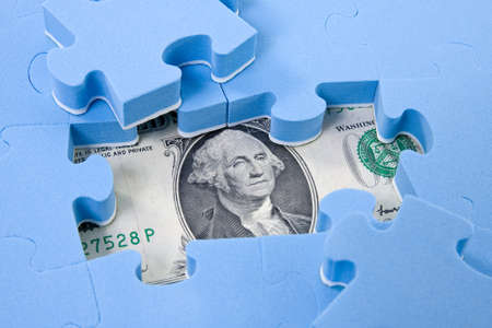 Hidden assets. Puzzle pieces on dollar backgroundの写真素材