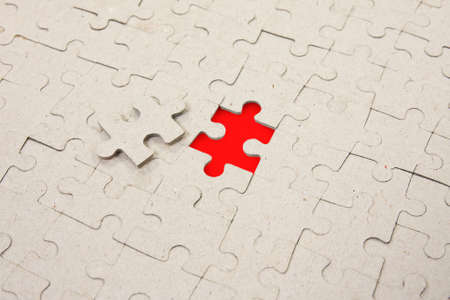 	papper puzzle background with one red piece missingの写真素材