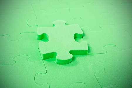 green puzzle with one piece pulled outの写真素材