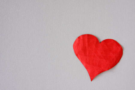 Crumpled red paper heart on a grey backgroundの写真素材