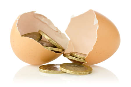 Broken  eggs with coins on white background 