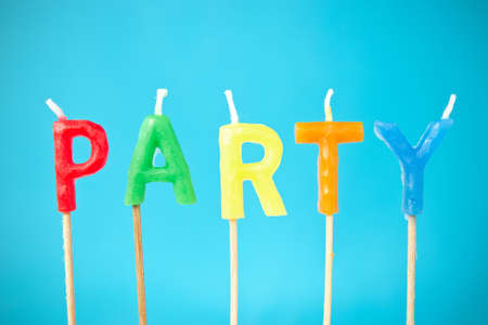 word  "Party"  made from color candles on blue backgroundの写真素材