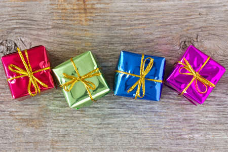 Four colorful gift boxes on the wooden floor