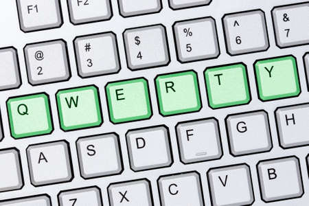 Green qwerty buttons on silver computer keyboard の写真素材