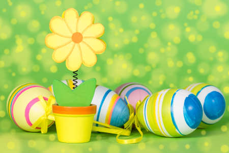 Decorative flower and Easter eggs on the green background