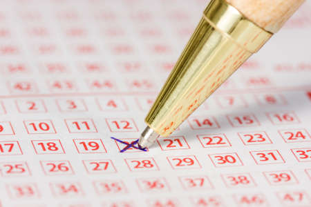 Close up of lottery ticket with a marked number and a penの写真素材