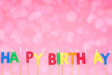 Happy birthday candles on the festive  pink  backgroundの写真素材