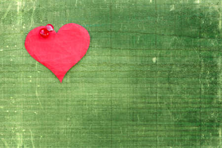 Paper heart pinned to the green wooden wallの写真素材