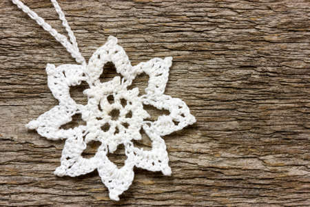 Crochet christmas snowflake  hanging on wooden wallの写真素材