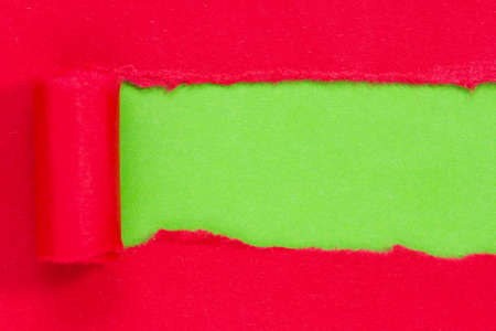 Red paper torn to reveal green panel ideal for copy spaceの写真素材