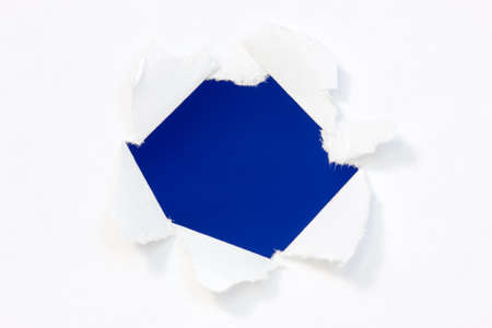 Hole in a paper with blue background inside の写真素材