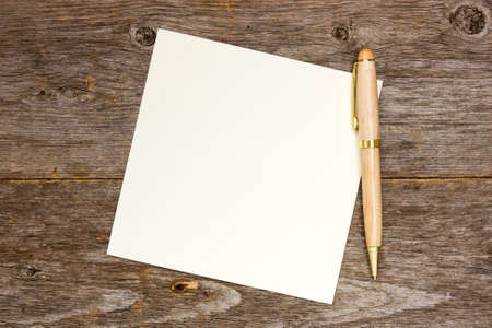 Empty note paper with pen on the wooden backgroundの写真素材