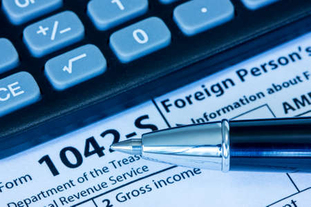 US tax form 1042-S with pen and calculatorの写真素材