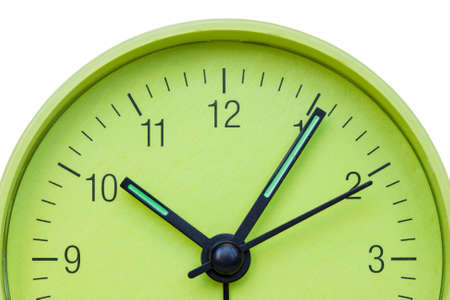 Closeup of hands on green clock face over a white backgroundの写真素材