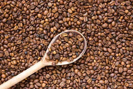 Coffee beans in an old wooden scoop の写真素材