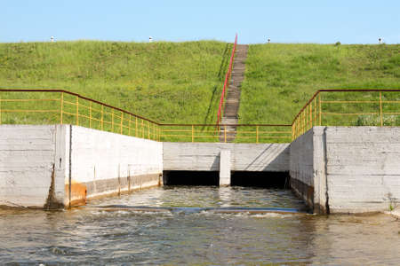Water flowing over floodgates of a small damの写真素材