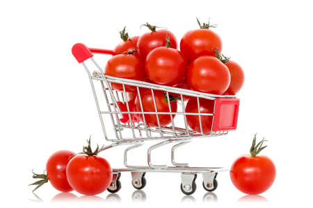 Shopping cart full of tomatoes. Isolated on white backgroundの写真素材