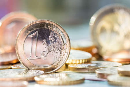 One euro coin on pile of euro coins in backgroundの写真素材