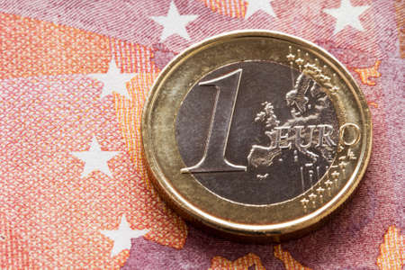 One Euro coin on ten Euros backgroundの写真素材