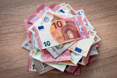 Pile of Euros on the wooden surface