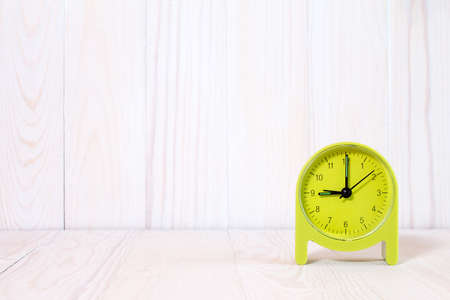 Green alarm clock on wood background. With copy-space for textの写真素材