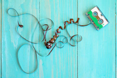 Retro audio cassette with pulled out tape on the blue  backgroundの写真素材