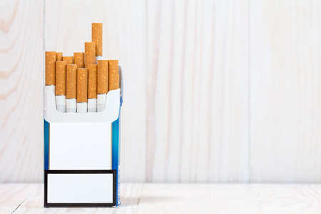 Pack of cigarettes on white wood  background. With copy-space for textの写真素材