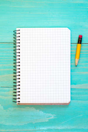 Open notebook and pencil on the blue wooden surface