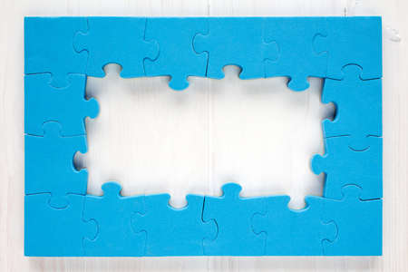 Blue puzzle frame on white wooden backgroundの写真素材