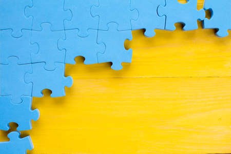 Puzzle on yellow wooden background.Team business conceptの写真素材