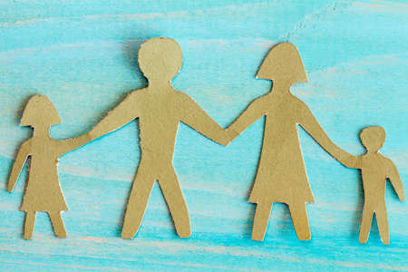 Cardboard figures of the family on a bluewooden backgroundの写真素材