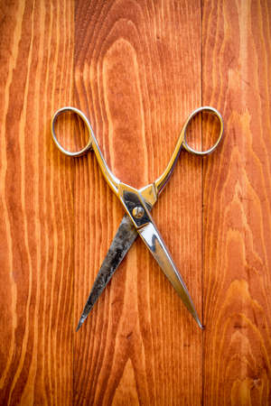 Vintage scissors on a wooden work tableの写真素材