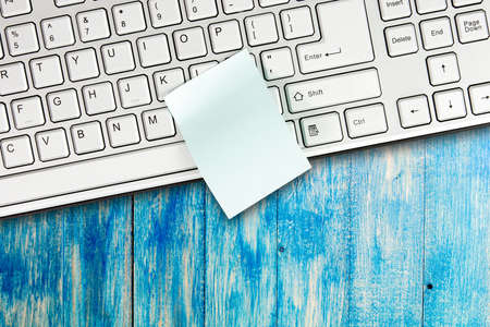 Sticky note is on the keyboard of a computer as a reminder: emptyの写真素材