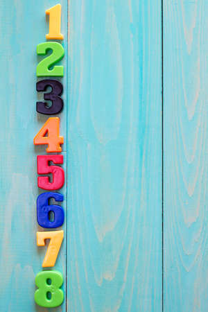 Set of plastic numbers on wooden background with copy-space