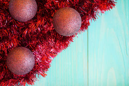 Red tinsel and Christmas balls on blue background