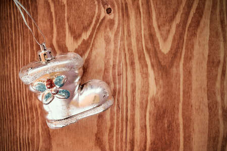 Old shoe shaped christmas bauble hanging on wooden backgroundの写真素材