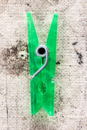 Close up view of  green plastic clothespin  on dirty backgroundの写真素材
