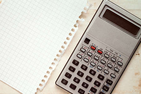 Old electronic calculator and blank square sheet of paperの写真素材