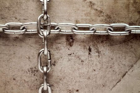 Two chains crossed on old canvas background. Grunge style image.の写真素材