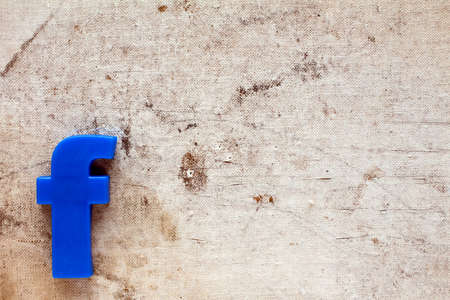 Blue plastic letter F on canvas background with copy-space