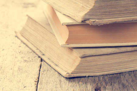 Books on wooden background in vintage tone color