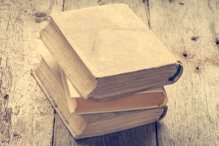 Old books on wooden background in vintage tone color