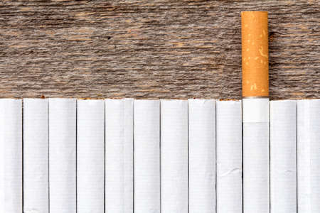 Cigarette addiction concept. Row of cigarettes on a wooden background.の写真素材