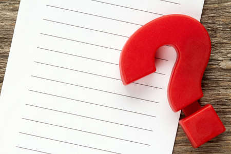 Note paper with red plastic question mark