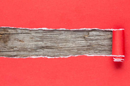 Torn red paper on wooden background with space for textの写真素材