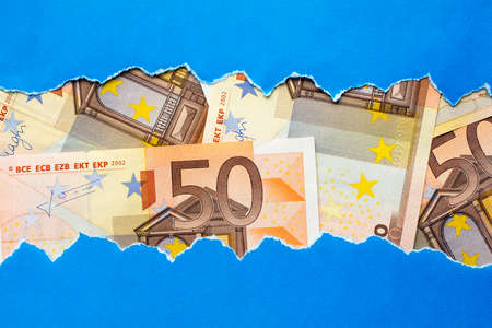 Fifty Euro bills in torn blue paper frameの写真素材