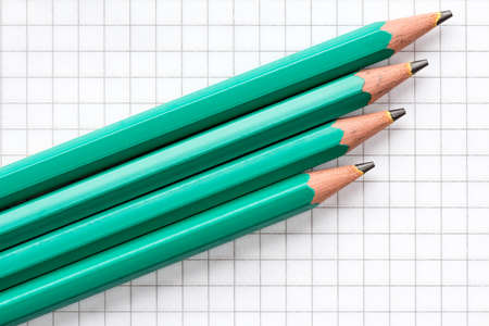 Four Pencils on Traditional Squared Paper for Schoolの写真素材
