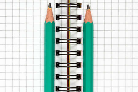 Close-up of spiral notebook and two pencils
