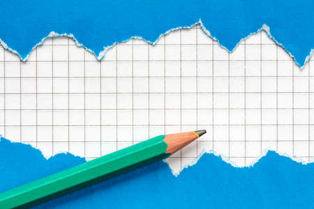 Pencil and torn blue paper with a squared paper background
